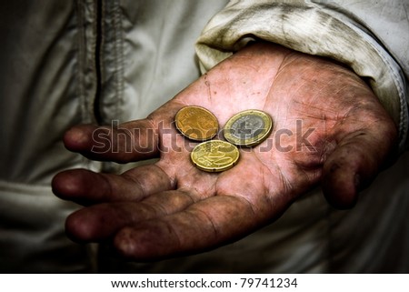 A beggar with some coins on his dirty hands