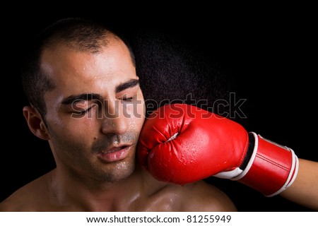 Image of a young boxer getting punched in the face over black background