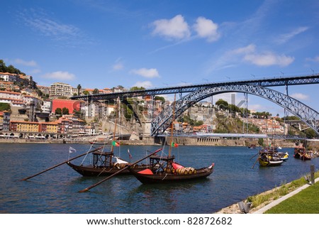 Tradicional vintage port transporting boats near famous bridge Ponte dom Luis I, Portugal
