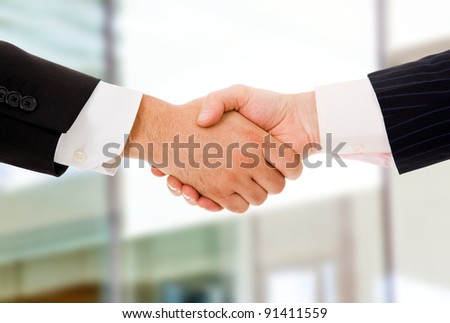 Closeup picture of businesspeople shaking hands, making an agreement at the office.