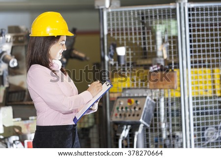 Mechanical engineer taking notes at metallurgy factory