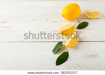 Juicy lemons with leaves on a white wooden background. Lemon slices. Lemon. Lemons. Citrus. Fruit. Fruits. Fresh Lemon. Juicy Lemons. Fresh Citrus. Fresh Fruit. Juicy Fruits.