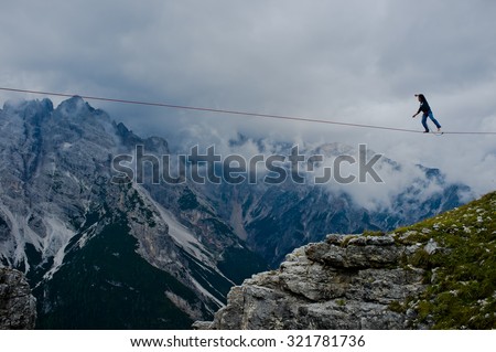 MONTE PIANA, DOLOMITES/ITALY - SEPTEMBER 08, 2013: an acrobat on a rope tended above an abyss during 