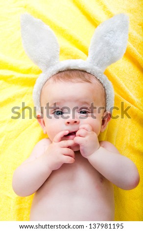 Cute boy with bunny ears sucks his fingers