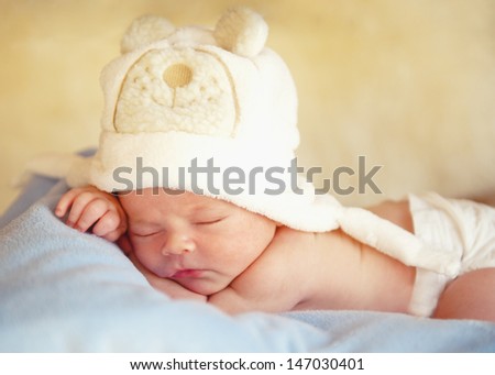 Newborn baby in the cap bear sleeps.