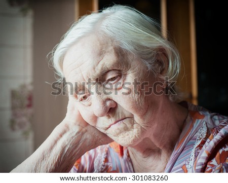 Pretty old grandmother sitting alone thinking cute