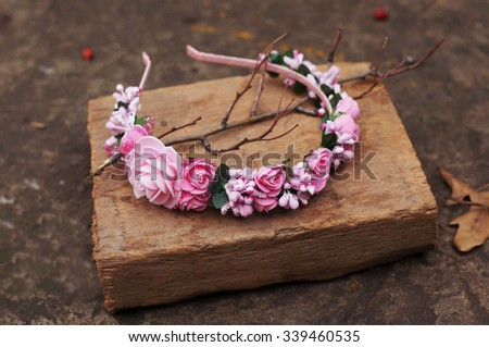 Hoop from flowers, wreath with colored flowers. Handmade flowers wreath on outdoor wooden stand.  Accessory. Artificial flowers. Hair accessories. Beauty. Fashion. Decoration for the head. Wreath hair
