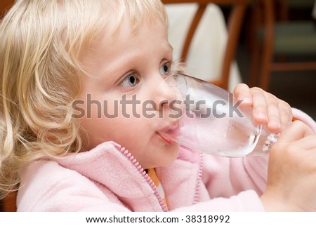 Little girl drinking water in  restaurant
