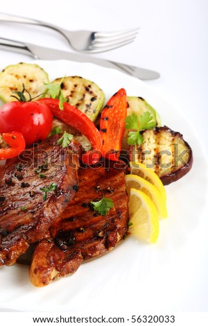 Grilled steak meat with vegetables on a white background