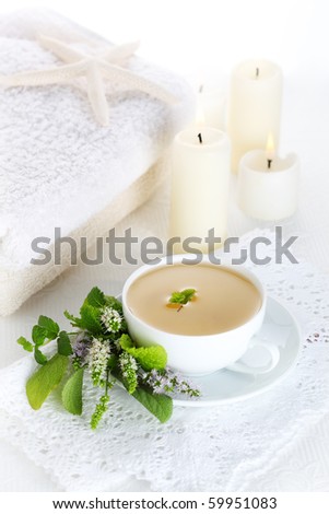 cup of herbal tea on a white background with candles, healthy lifestyle