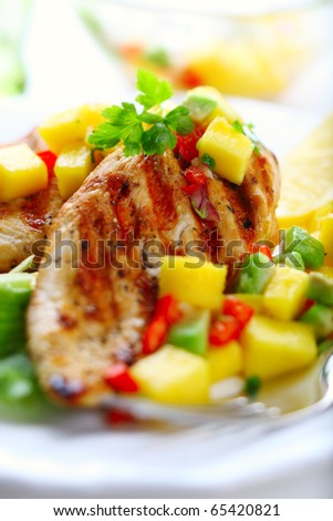 Grilled chicken breast with fresh mango salsa, soft focus