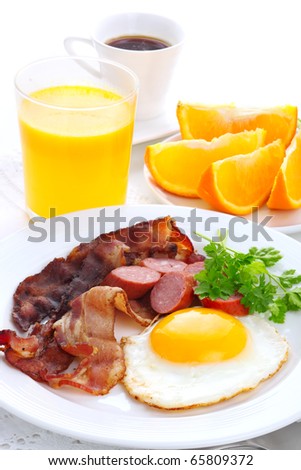 Breakfast with bacon, fried egg and orange juice