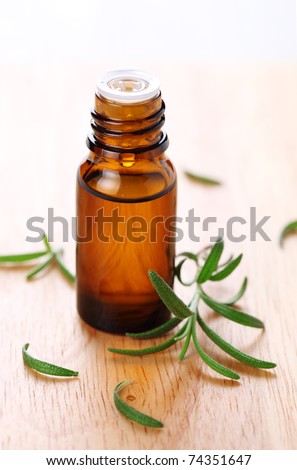 bottle of aromatic essence oil and fresh rosemary