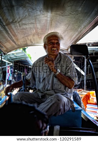 BANGKOK, THAILAND -AUGUST 5: An unidentified longboat driver takes tourists to the floating markets on August 5, 2012 in Bangkok. The famous floating markets, sales take place from longboats.