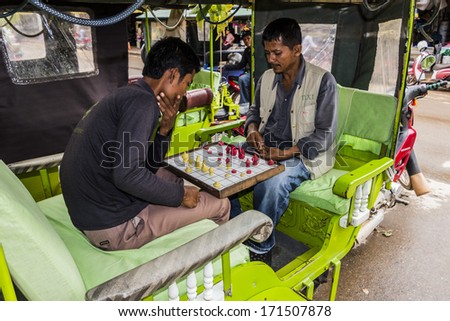 SIEM REAP, CAMBODIA- SEPT 21: Drivers resting playing a game in Siem Reap, Cambodia, September 21st  2013, Siem Reap, Cambodia, Tuk Tuk drivers resting playing a game to pass the time between fares