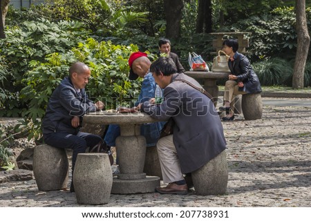 SHANGHAI, CHINA - 28th MARCH 2014: peoples square where people meet to talk and play board games in the park every morning