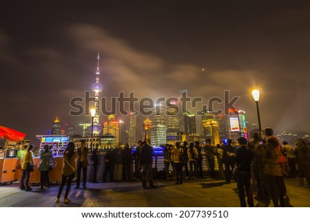 SHANGHAI, CHINA - 28th MARCH 2014: The Bund is a great place to people watch, the city scape comes alive at night