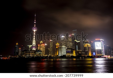 SHANGHAI, CHINA - 28 MARCH 2014: The Bund is a great place to people watch, the city scape comes alive at night
