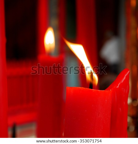 The flame on red candle at the Chinese temple.