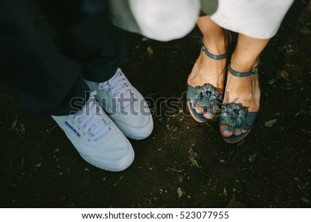 Closeup of hipster wedding couple`s feet outdoors