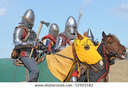 Horse knights in the heavy armour, armed with swords and the axes, prepared for fight