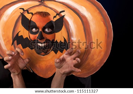 Young man in  funny Halloween Pumpkin costume.Scary Halloween Pumpkin Man preparing to attack you with a smile