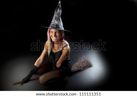 Beautiful smiling young woman in witch costume. Sexy Holloween Witch who rides on a broom