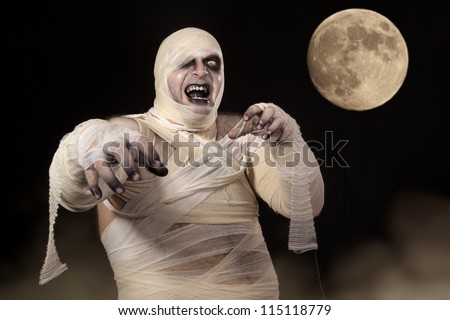 Scary Halloween Mummy in the mist. Young men in mummy costume