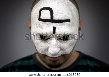 Painted face, black and white paint on young man  face. Cracked paint. Tongue sticking out emoticon drawn on head .  part of large series of paintesd tribal portraits