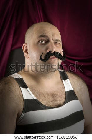 Vintage circus strongman with big mustache. Bald strong man with striped t- shirt. Part of larger vintage collection.