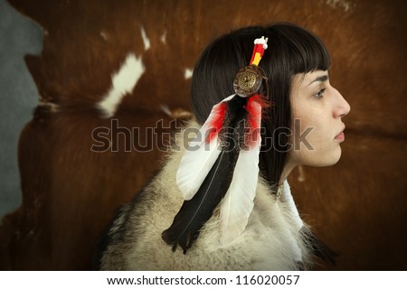 Native american woman profile  portrait. Young beautiful woman in native american costume with wolf fur feather head decoration