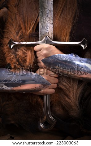 Beautiful redheaded girl as shieldmaiden,viking warrior woman holding a sword