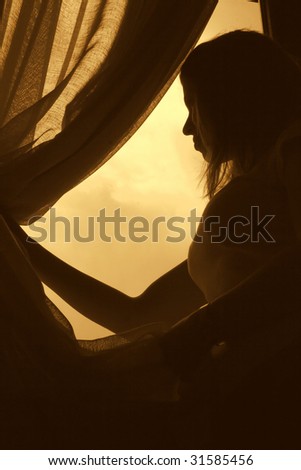 silhouette of woman looking through curtains at open window in hotel,back lit-2