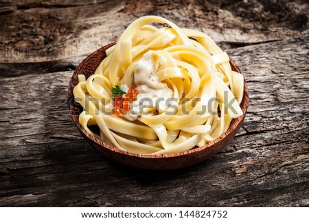 Pasta. Noodles with sauce and red caviar