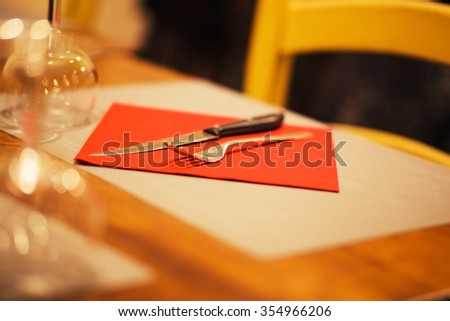 photo of table setting with napkin, silverware in a bright red color
