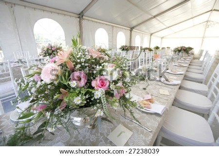 A table setup for a wedding reception in a big tent
