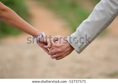 A caucasian bride and groom holding hands after they got married.