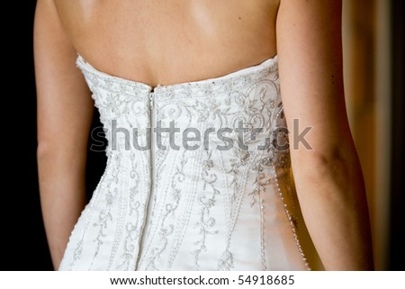 A close up of a caucasian bride\'s wedding dress at the back