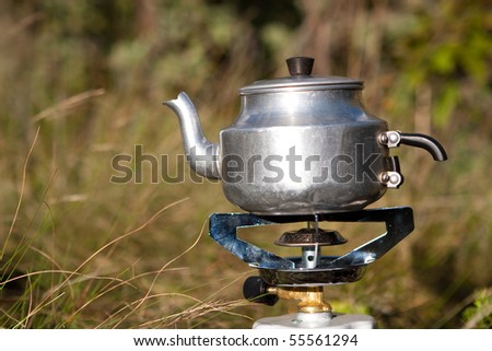 A camping kettle on a gas stove outdoors