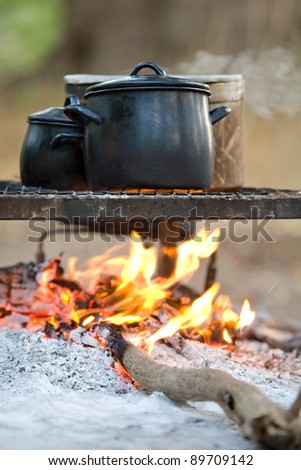 Three cooking pots on an open fire photographed at eye level