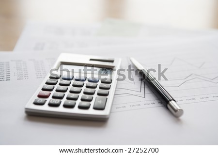 Pen & calculator on finance documents.  Logos, numbers, signature etc have been removed or changed to make unidentifiable