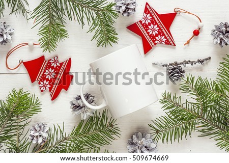 White coffee mug with Christmas decorations and fir branches. Space for text or design. Christmas concept white coffee mug. Top view.
