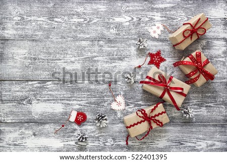 Gift boxes with red ribbon, Christmas decorations and pine cones on gray wooden table. Christmas background. Space for text. Top view.