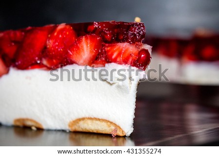 Strawberry jelly cake, Fresh Strawberry cake close-up.Fresh Strawberry cake with jelly and with pieces of fruit on a black plate. Homemade trawberry cake Food background. delicious dessert cheesecake.