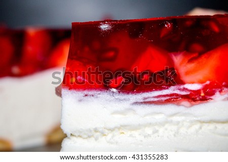 Strawberry jelly cake, Fresh Strawberry cake close-up. Fresh Strawberry cake with jelly and with pieces of fruit on a black plate. Homemade trawberry cake. Food background. delicious dessert