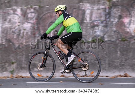 ROME, ITALY - NOVEMBER 07 2015: Urban cyclist riding on cycle lane in the street of Rome, Italy