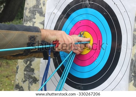 The man pulls the arrow from the target