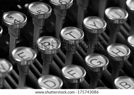Closeup of vintage typewriter keyboard focus on letter T area, in black and white.