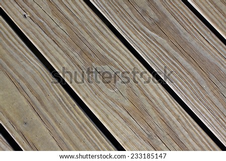 Closeup of wooden boards with nails, wood grain, and spaces between boards.