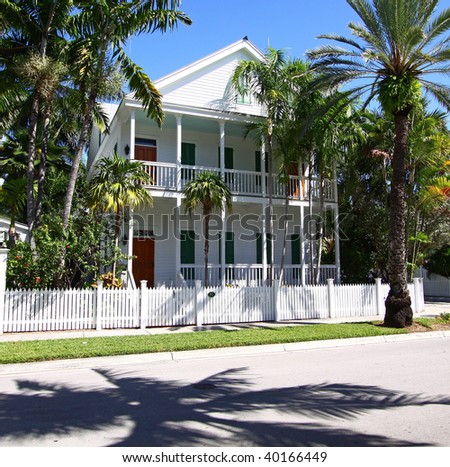 Typical Key-West, Florida house with porches, shutters, and white fence.